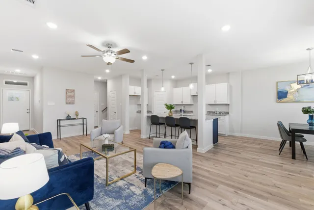 a living room with furniture a dining table and kitchen view