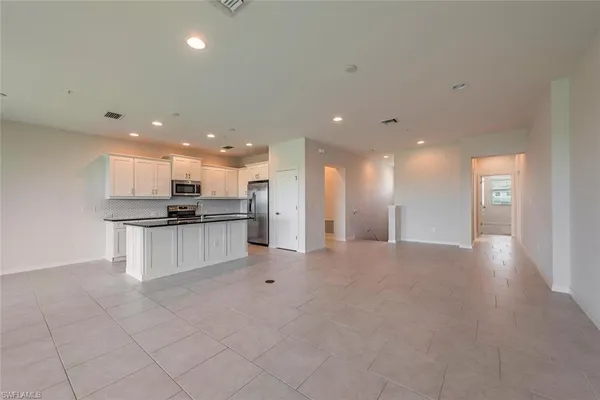 a view of kitchen with kitchen island white cabinets and stainless steel appliances