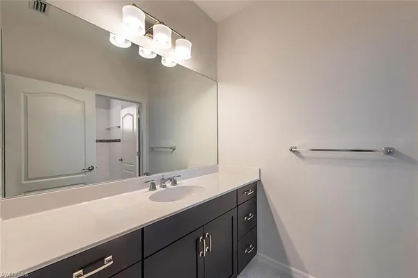 a bathroom with a sink a light fixture and a mirror