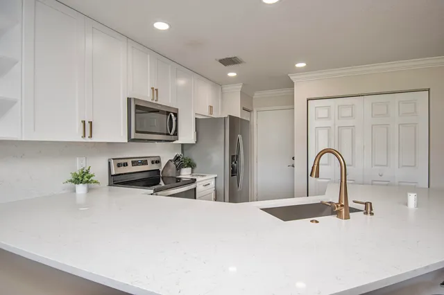 a kitchen with stainless steel appliances a sink microwave and cabinets
