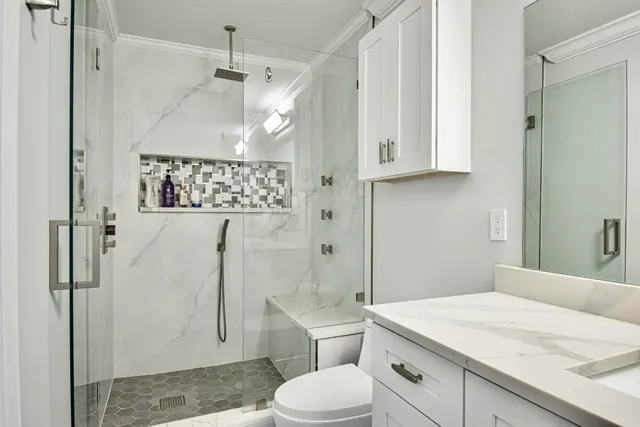 a bathroom with a sink a toilet and shower