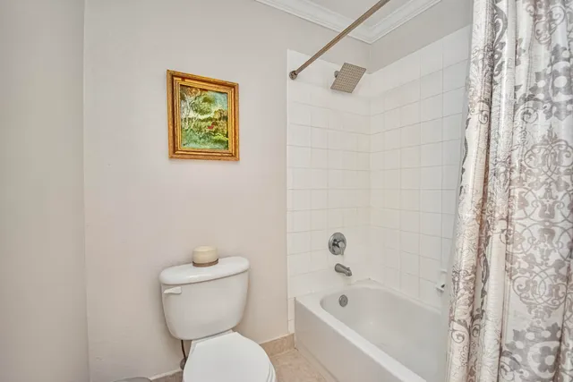 a white toilet sitting next to a bath tub
