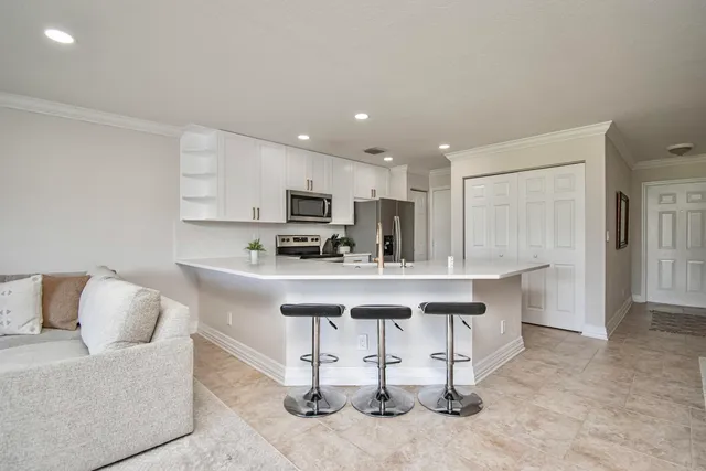 a living room with stainless steel appliances kitchen island granite countertop furniture and a view of kitchen