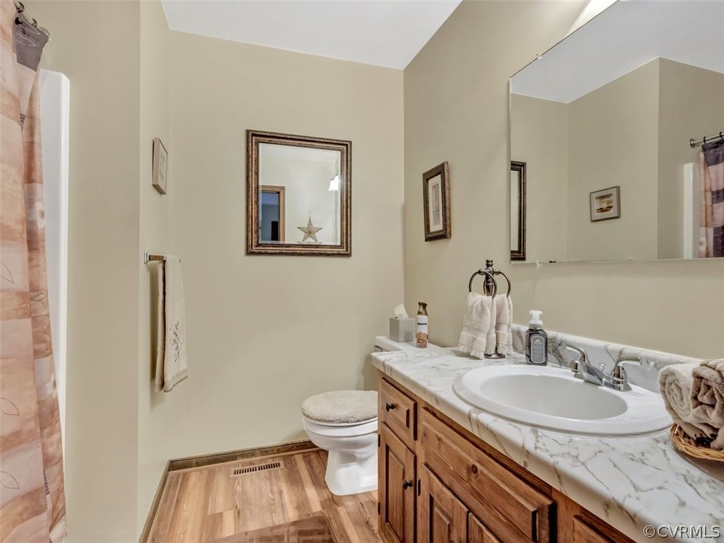 7713 Drexelbrook Road Chesterfield, VA 23832 - Photo 17 of 22 a bathroom with a granite countertop toilet a sink and a mirror