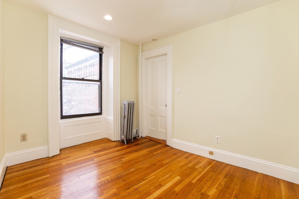 41 Worcester Square, Unit 5 Boston, MA 02118 - Photo 12 of 17 a view of an empty room with wooden floor and a window