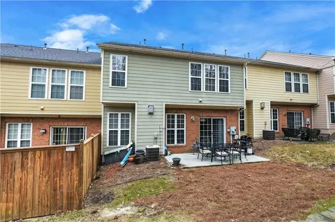 a view of a house with a patio and a yard
