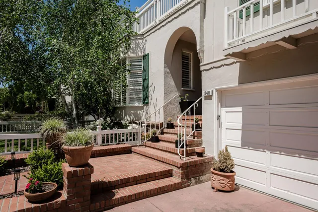 a view of a patio with couches table and chairs and potted plants