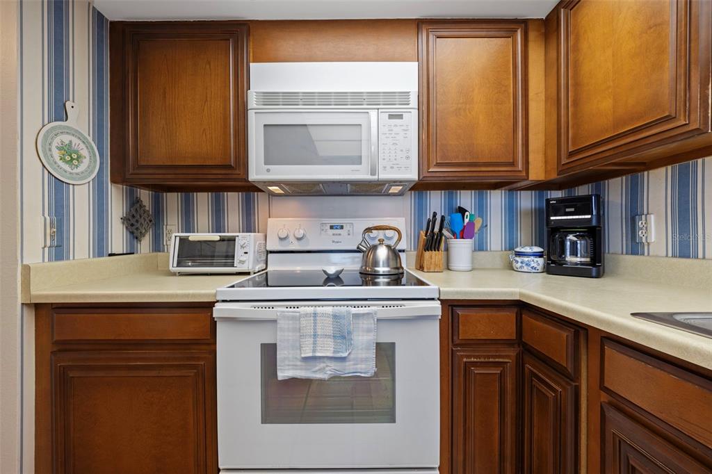 9425 Blind Pass Road, Unit 1006 St. Pete Beach, FL 33706 - Photo 11 of 45 a kitchen with stainless steel appliances granite countertop a sink and cabinets