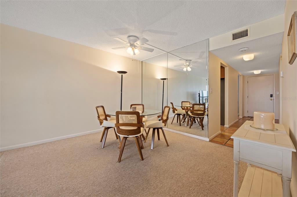 9425 Blind Pass Road, Unit 1006 St. Pete Beach, FL 33706 - Photo 13 of 45 a dining room with furniture and a chandelier
