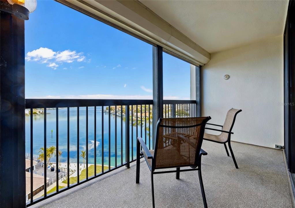 9425 Blind Pass Road, Unit 1006 St. Pete Beach, FL 33706 - Photo 16 of 45 a view of a balcony with furniture and a potted plant
