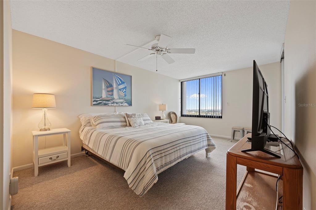 9425 Blind Pass Road, Unit 1006 St. Pete Beach, FL 33706 - Photo 19 of 45 a bedroom with a bed flat screen tv and window