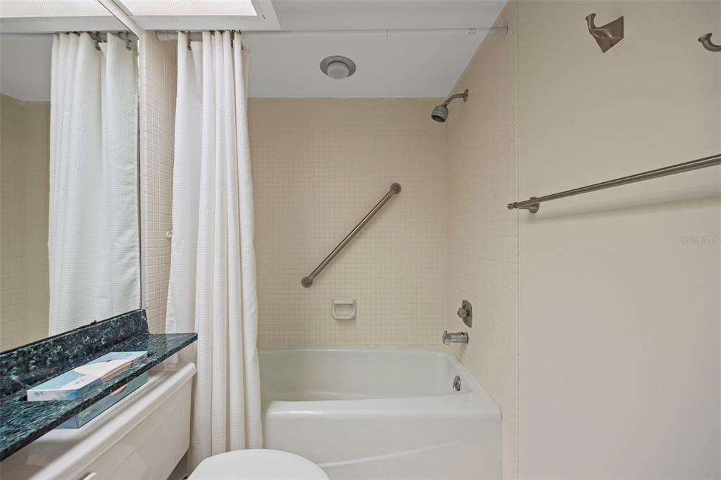 9425 Blind Pass Road, Unit 1006 St. Pete Beach, FL 33706 - Photo 24 of 45 a bathroom with a bathtub and a shower