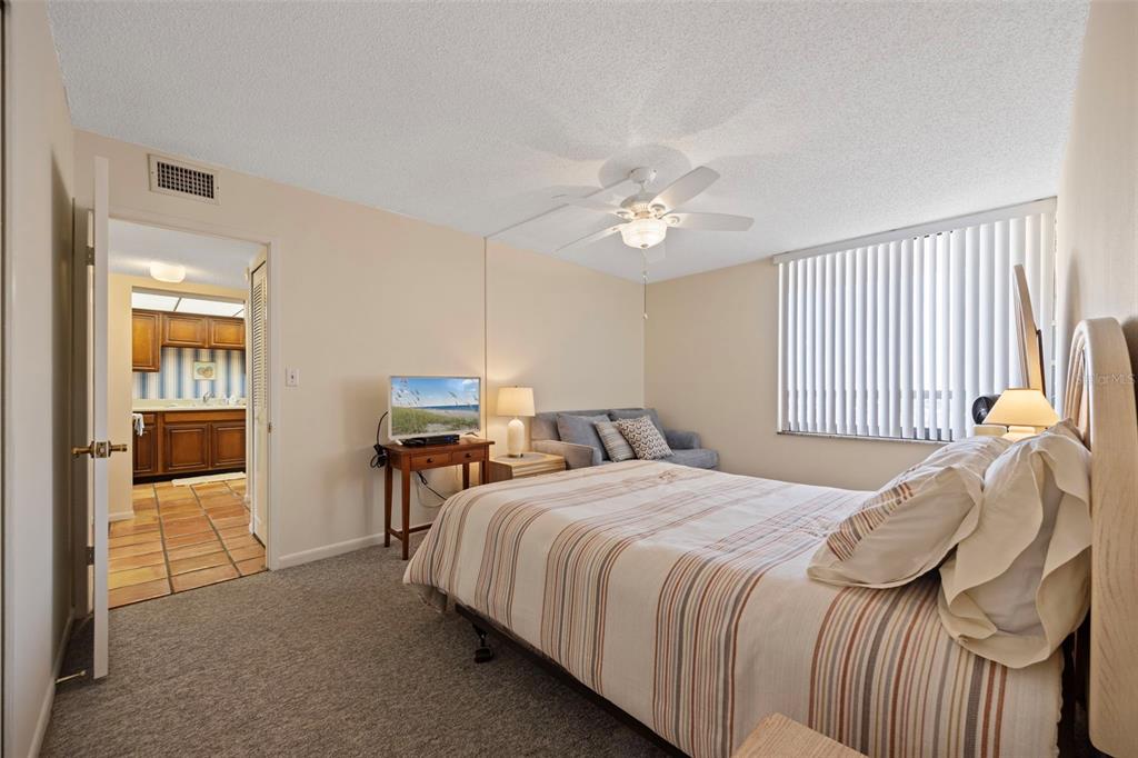 9425 Blind Pass Road, Unit 1006 St. Pete Beach, FL 33706 - Photo 26 of 45 a bedroom with a bed and a chandelier