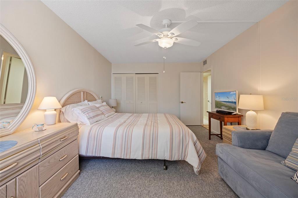 9425 Blind Pass Road, Unit 1006 St. Pete Beach, FL 33706 - Photo 27 of 45 a spacious bedroom with a bed and a chandelier