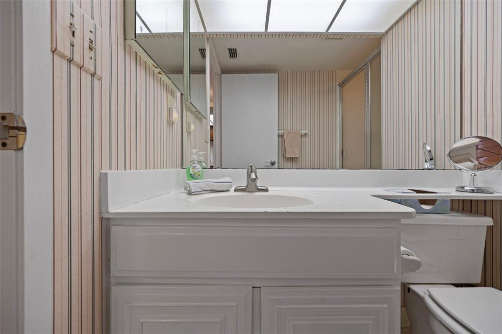 9425 Blind Pass Road, Unit 1006 St. Pete Beach, FL 33706 - Photo 29 of 45 a bathroom with a sink and a mirror