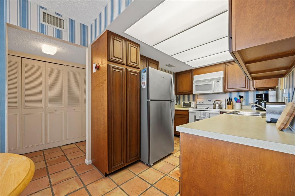 9425 Blind Pass Road, Unit 1006 St. Pete Beach, FL 33706 - Photo 8 of 45 a kitchen with stainless steel appliances a refrigerator and a sink