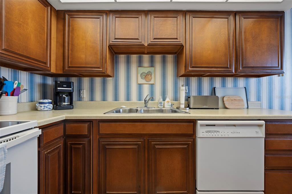 9425 Blind Pass Road, Unit 1006 St. Pete Beach, FL 33706 - Photo 10 of 45 a kitchen with stainless steel appliances granite countertop a sink and cabinets
