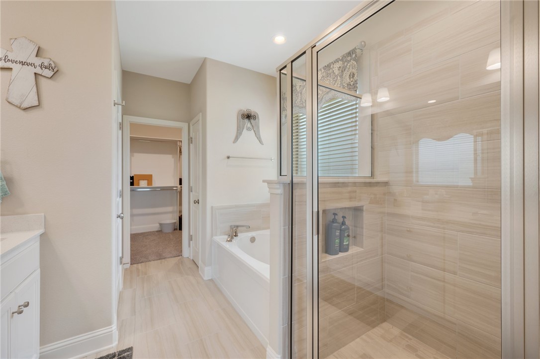 4261 Harding Way Bryan, TX 77802 - Photo 15 of 27 a bathroom with a glass shower door and a sink
