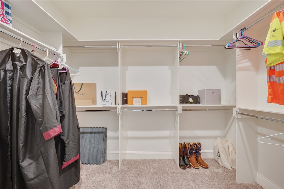 4261 Harding Way Bryan, TX 77802 - Photo 16 of 27 a view of walk in closet with clothes and shoes