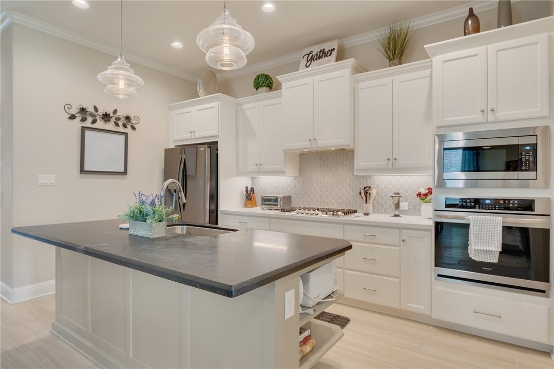4261 Harding Way Bryan, TX 77802 - Photo 5 of 27 a kitchen with kitchen island granite countertop a sink cabinets and stainless steel appliances