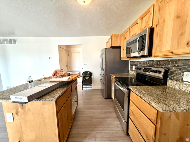1823 South Longview Road Santaquin, UT 84655 - Photo 20 of 69 Kitchen featuring light wood cabinetry, granite countertops, stainless steel appliances, and a tiled backsplash