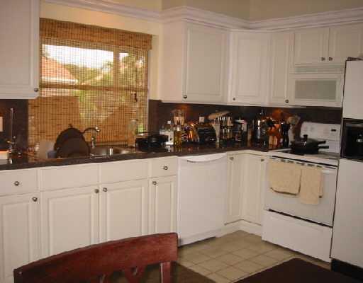 1249 Southwest 12th Avenue Boca Raton, FL 33486 - Photo 5 of 8 a kitchen with white cabinets and window