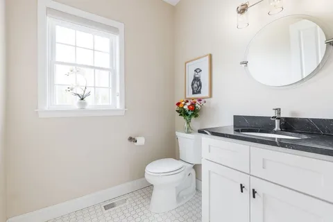 a bathroom with a toilet a sink and mirror