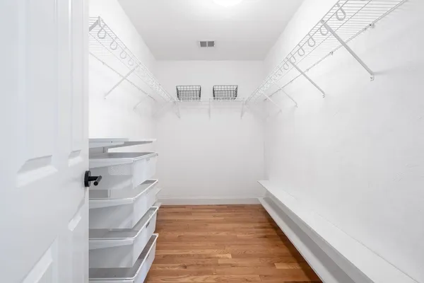a view of walk in closet with empty racks