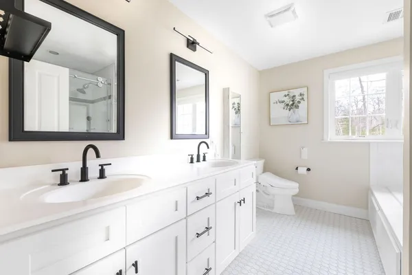 a bathroom with double vanity sink a mirror and a toilet