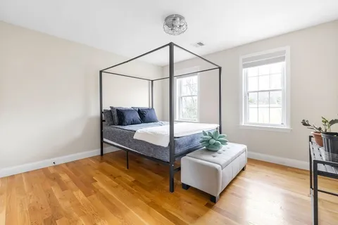 a bedroom with a bed and wooden floor