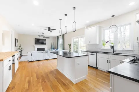 a kitchen with stainless steel appliances granite countertop a sink a stove and wooden floor
