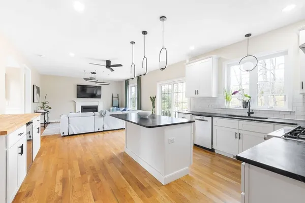a kitchen with stainless steel appliances granite countertop a sink a stove and wooden floor