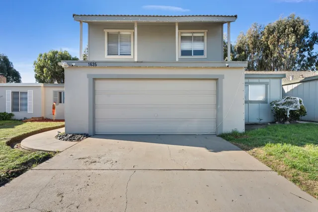 a front view of a house with a yard and garage