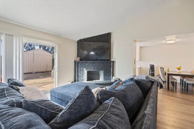 a living room with furniture a large window and a fireplace