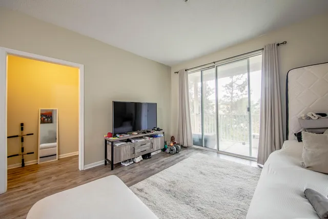 a bedroom with a bed and large windows