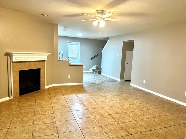 a view of empty room with a fireplace and fan