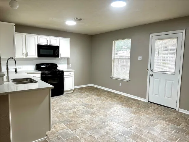 a view of a kitchen with a sink a refrigerator and a stove top oven