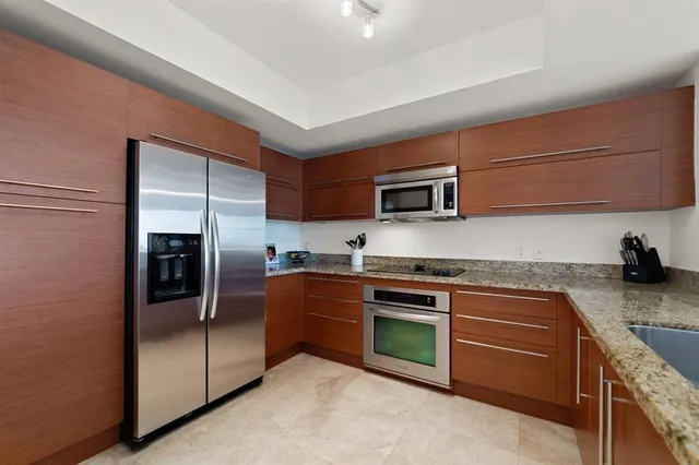 a kitchen with stainless steel appliances granite countertop a refrigerator stove and sink