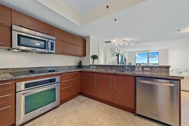 a kitchen with stainless steel appliances granite countertop a stove and a microwave