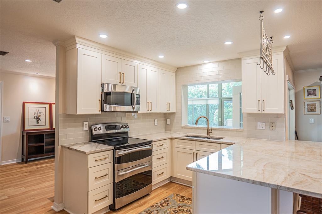 741 Brookside Road Maitland, FL 32751 - Photo 4 of 43 a kitchen with kitchen island white cabinets and appliances