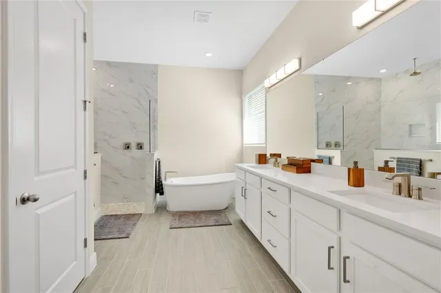 a bathroom with a double vanity sink a toilet and shower