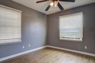 2320 26th Street Lubbock, TX 79411 - Photo 9 of 17 a view of an empty room with a window and wooden floor