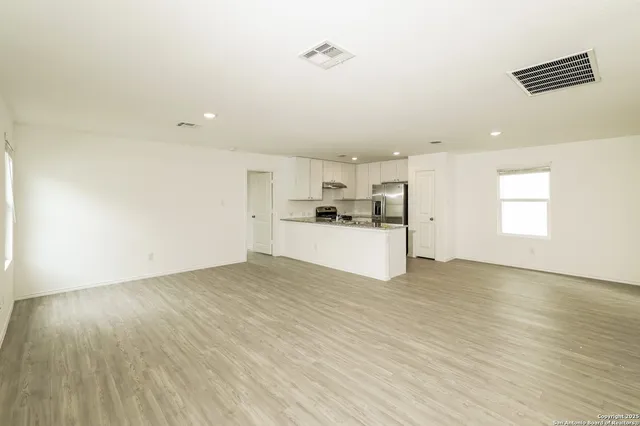 a view of a kitchen with a sink and dishwasher a refrigerator with wooden floor