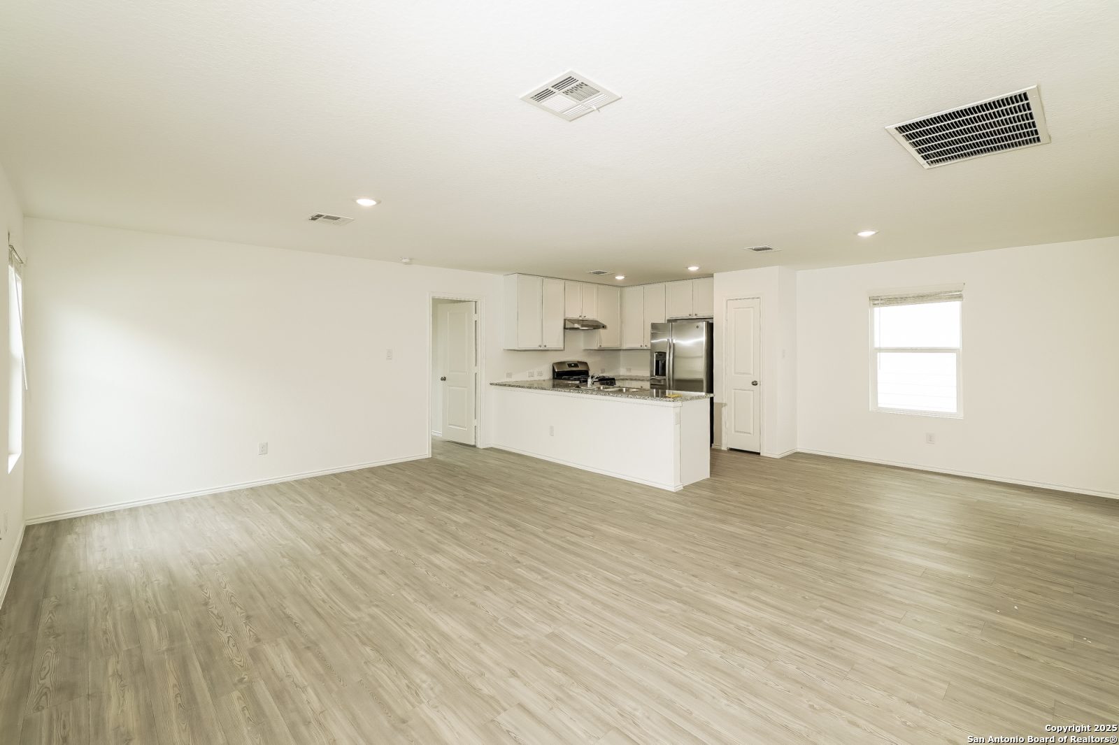 20358 Andesine Ridge San Antonio, TX 78264 - Photo 3 of 14 a view of a kitchen with a sink and dishwasher a refrigerator with wooden floor