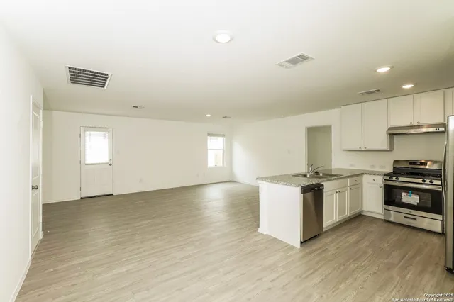 a kitchen with a stove top oven and cabinets