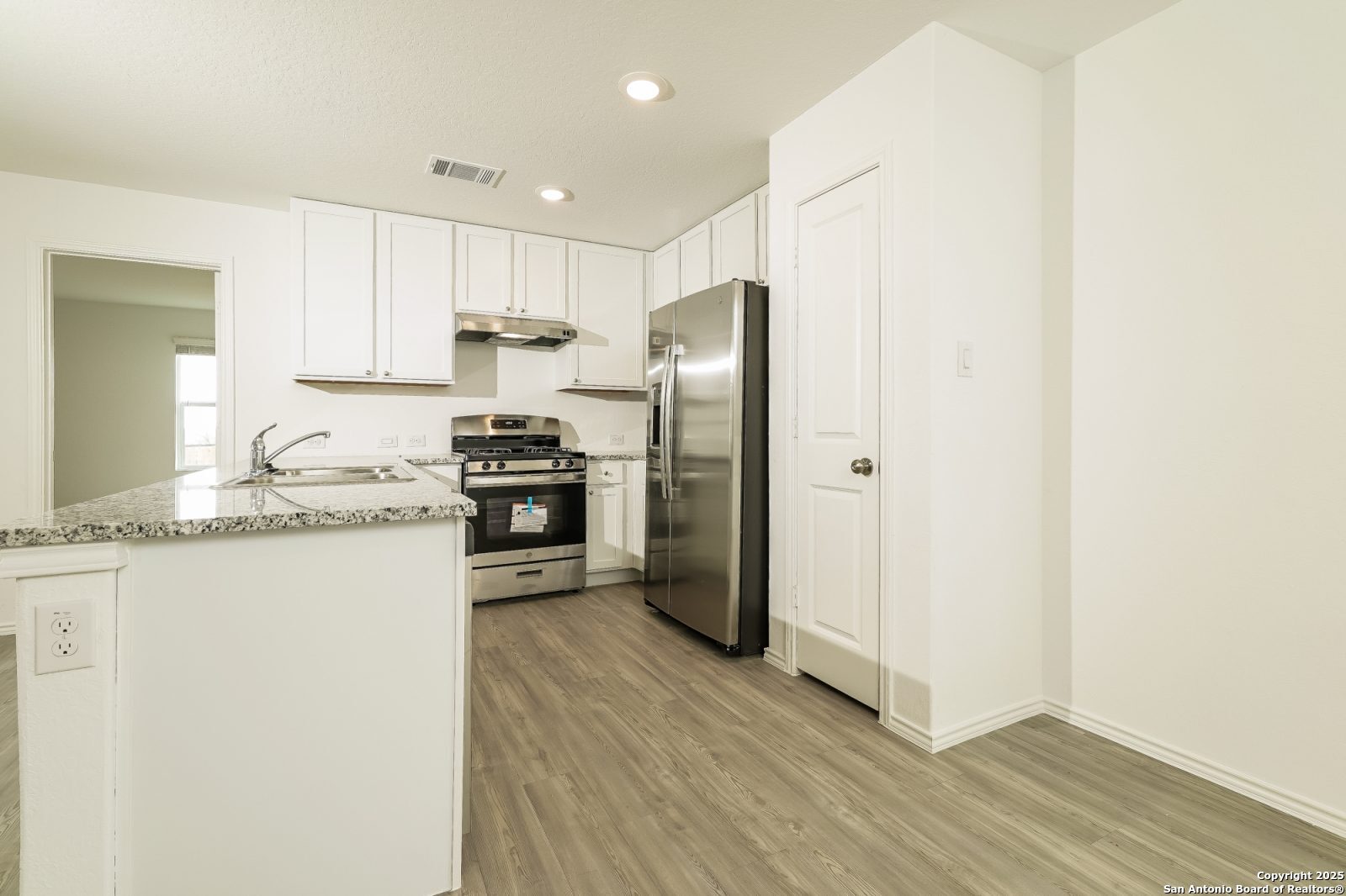 20358 Andesine Ridge San Antonio, TX 78264 - Photo 5 of 14 a kitchen with granite countertop white cabinets and stainless steel appliances