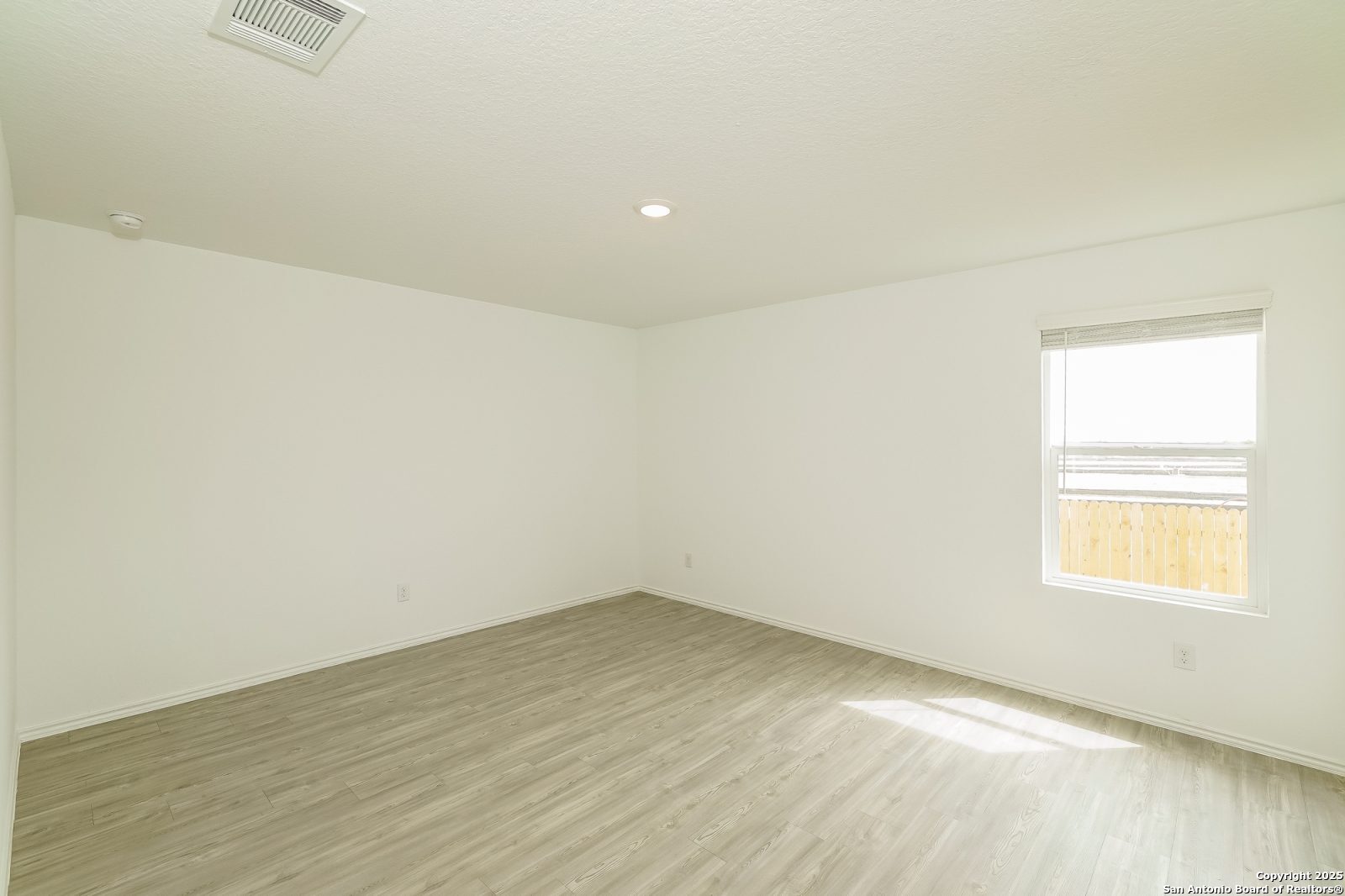 20358 Andesine Ridge San Antonio, TX 78264 - Photo 8 of 14 an empty room with wooden floor and windows