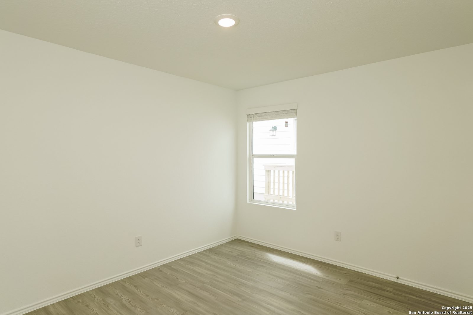 20358 Andesine Ridge San Antonio, TX 78264 - Photo 9 of 14 an empty room with wooden floor and windows