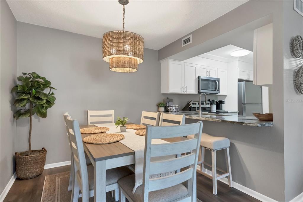 3239 South Beneva Road, Unit 101 Sarasota, FL 34232 - Photo 11 of 37 a kitchen with a table chairs stainless steel appliances and cabinets