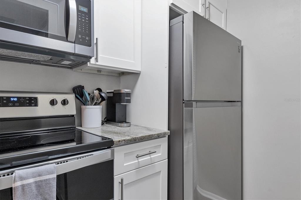 3239 South Beneva Road, Unit 101 Sarasota, FL 34232 - Photo 14 of 37 a kitchen with granite countertop cabinets and steel stainless steel appliances